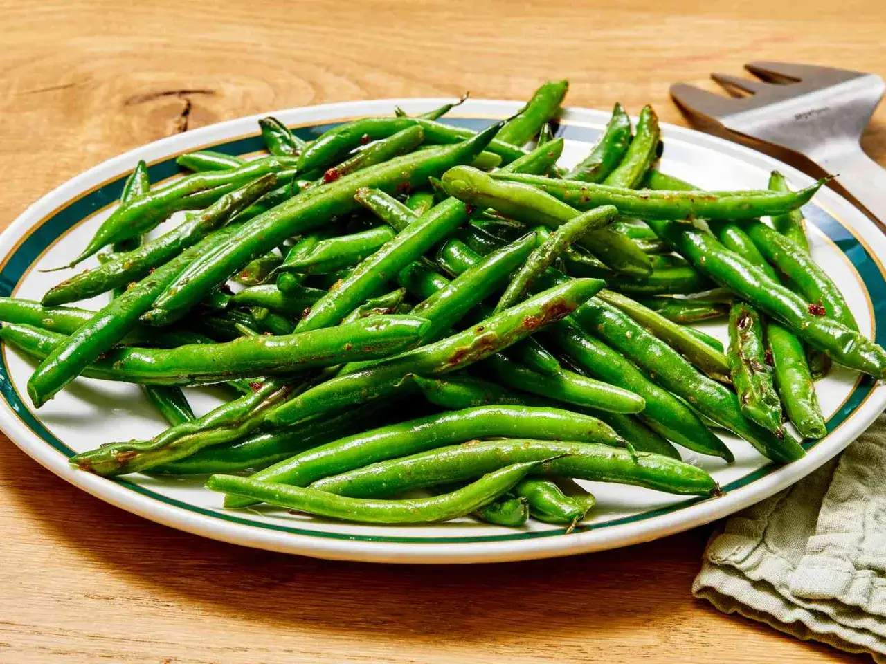 Assiette de haricots verts brillants, parfaitement cuits, prêts à être dégustés. La cuisson haricots verts révèle leur fraîcheur.