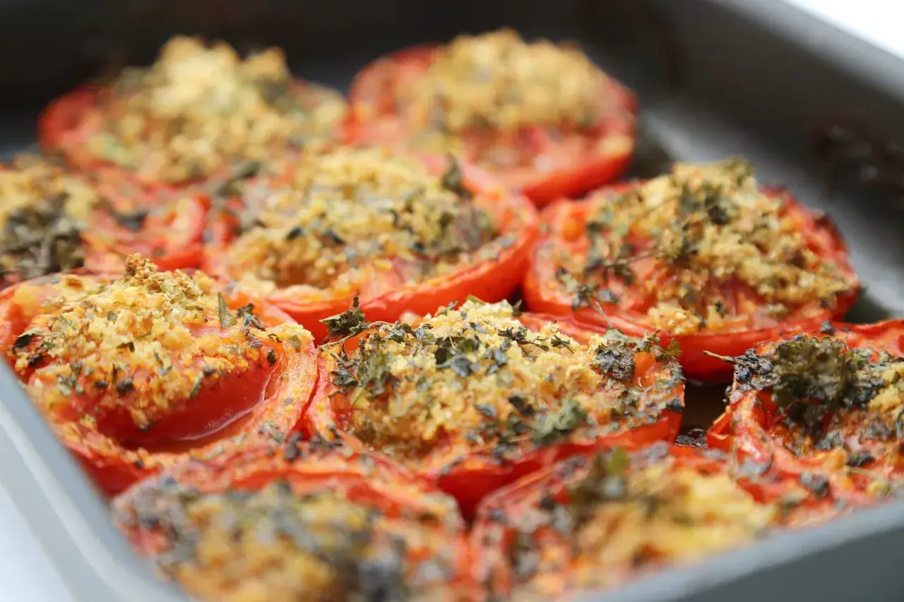 Tomates &agrave; la proven&ccedil;ale &agrave; la po&ecirc;le, garnies d'une chapelure dor&eacute;e et d'herbes aromatiques, pr&ecirc;tes &agrave; &ecirc;tre d&eacute;gust&eacute;es.