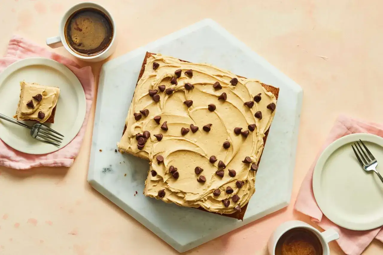 Un délicieux gâteau au beurre de cacahuète, généreusement garni de pépites de chocolat, prêt à être dégusté avec un café.