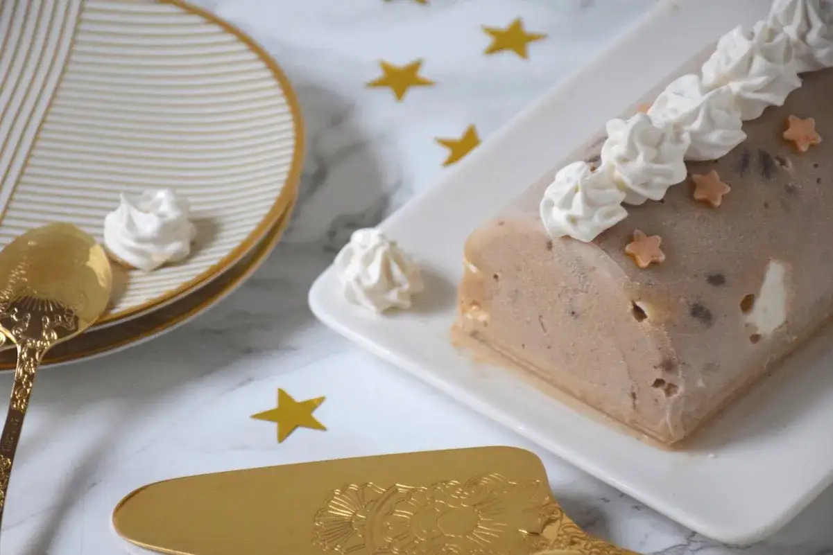 B&ucirc;che glac&eacute;e aux marrons, d&eacute;cor&eacute;e de cr&egrave;me fouett&eacute;e et d'&eacute;toiles. Parfaite pour une recette de f&ecirc;te.
