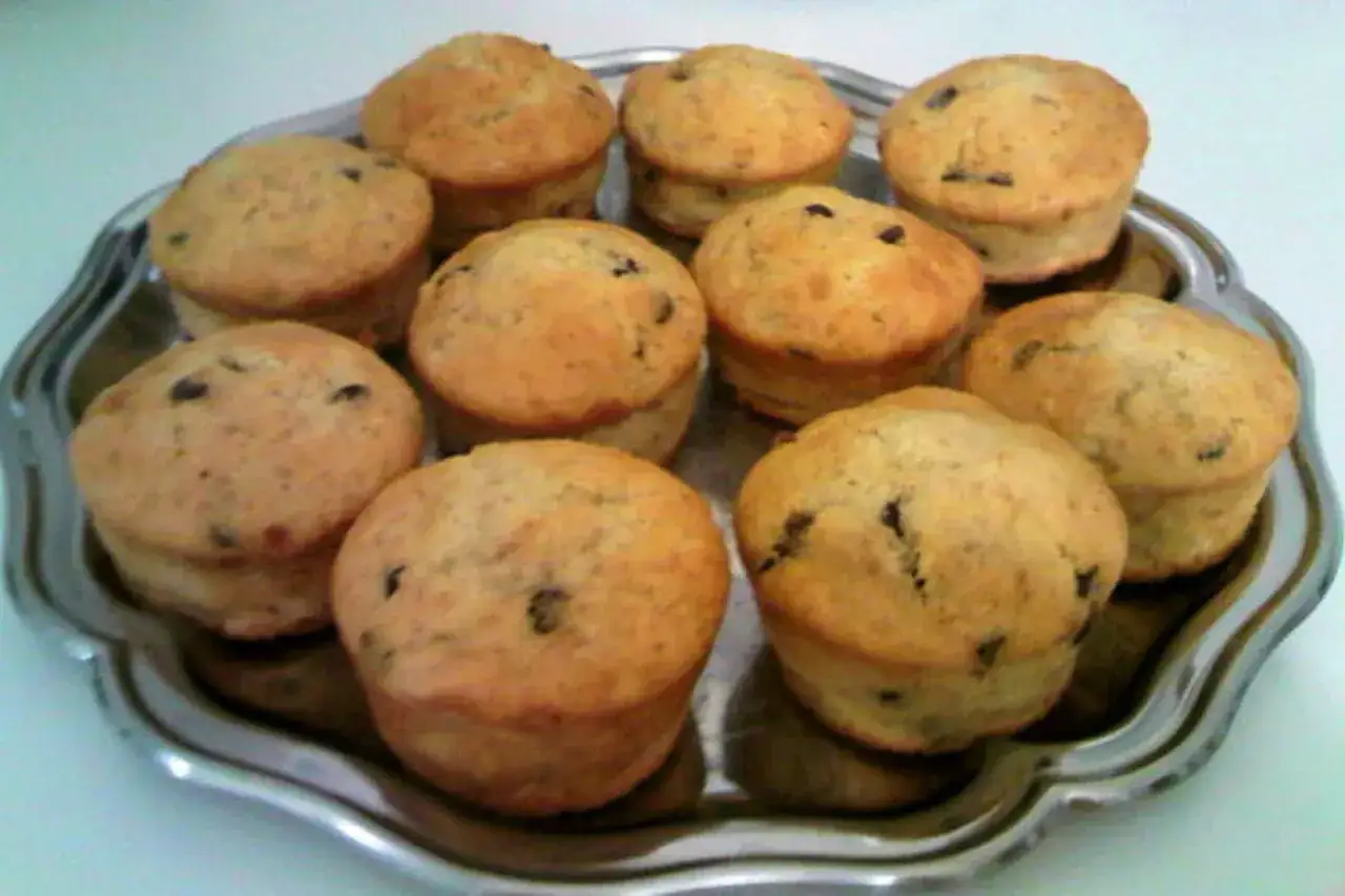 Dix muffins banane chocolat dorés et appétissants disposés sur un plateau argenté.