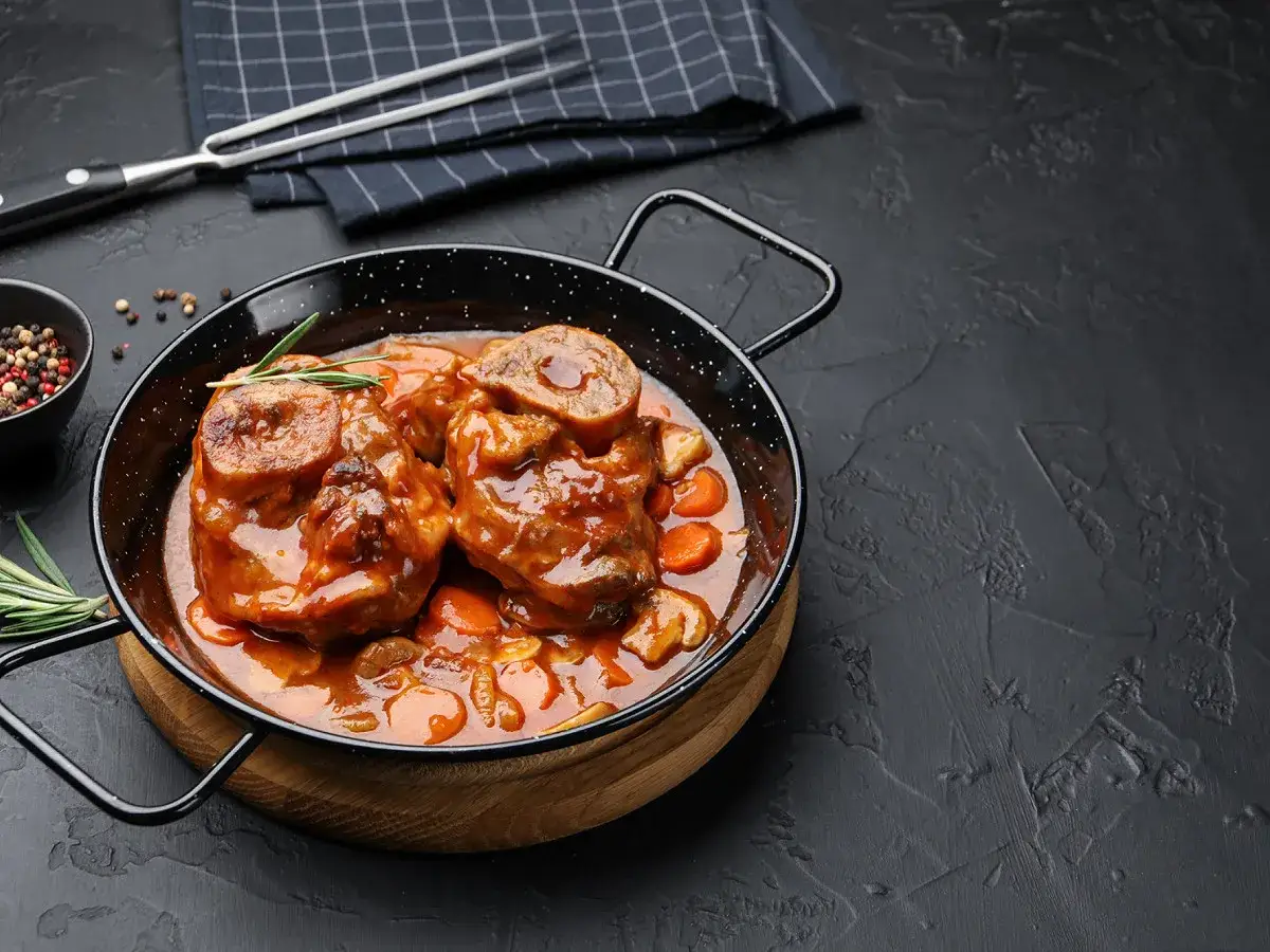 Un plat de boeuf miroton recette, avec des morceaux de viande tendres mijot&eacute;s dans une sauce riche aux carottes et champignons, garni de romarin.