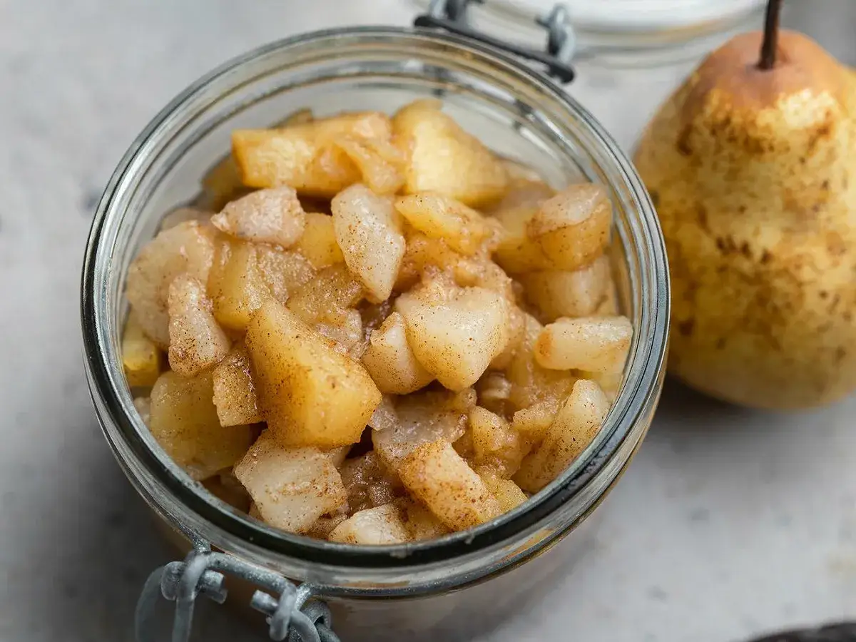 Compote maison de pomme poire vanille, aux morceaux tendres et parfum&eacute;s, dans un bocal en verre. Une poire enti&egrave;re &agrave; c&ocirc;t&eacute;.