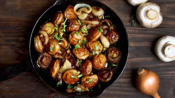 Poêlée de champignons et oignons caramélisés, une délicieuse cuisson des cèpes, garnie de persil frais.