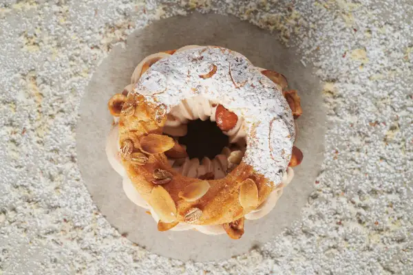 Un Paris-Brest gourmand, garni de crème onctueuse et d'amandes effilées. Une recette qui fait saliver !
