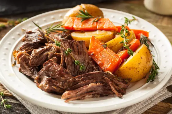 Un plat de bœuf effiloché, carottes et pommes de terre rôties, garni de thym frais. Une belle inspiration pour une recette bœuf carottes Laurent Mariotte.