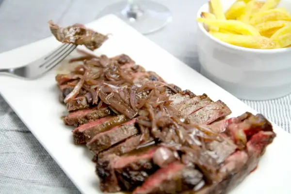 Tranches de bavette de bœuf savoureuses nappées d'une sauce échalote onctueuse, accompagnées de frites dorées. Un délice !
