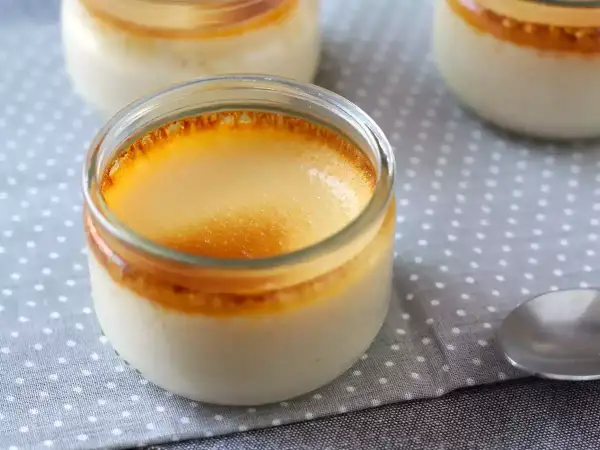 Crème aux œufs on a polka dot cloth, with a spoon nearby. The dessert has a golden, caramelized top.