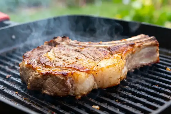 Une succulente basse côte de bœuf au barbecue, fumante et saisie à la perfection sur une grille.