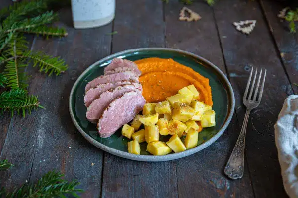 Tranches de magret de canard, purée de carottes et pommes de terre rôties. Le temps de cuisson magret de canard est parfait pour cette viande tendre.