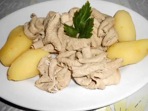 Une assiette de fraise de veau, tendres et savoureuses, accompagnée de pommes de terre vapeur et d'une touche de persil frais.
