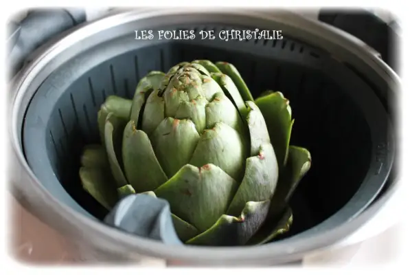 Un gros artichaut vert est prêt pour la cuisson vapeur. Le temps de cuisson vapeur de l'artichaut est bientôt terminé.