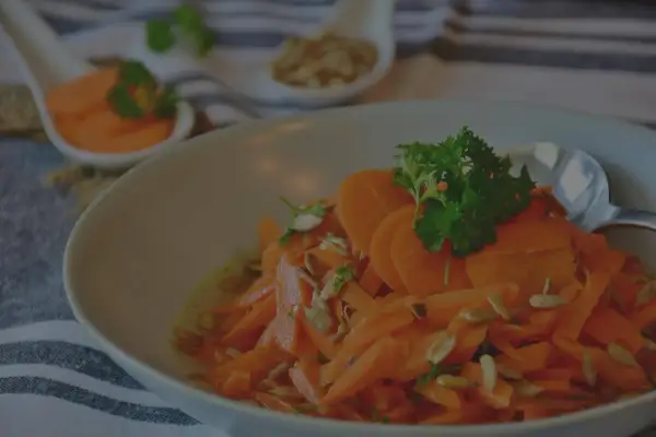 Carottes Vichy grand-mère, une salade fraîche et colorée, garnie de persil et de graines de tournesol. Un délice simple et savoureux.
