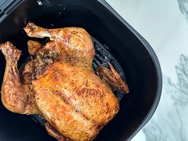 Un poulet entier doré et croustillant, prêt à être dégusté. Le temps de cuisson poulet airfryer est parfait pour un repas rapide et savoureux.